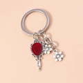 Macro shot of a vintage silver hand mirror keychain with a vibrant red heart gemstone - Red Hand Mirror Flower (YZ209)