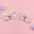 Detail view of two rainbow hair clips with glittery clouds on a soft pink background - Rainbow Bow Cloud Style (MS5227)
