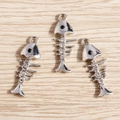 Detail of silver alloy fishbone charms with rhinestone eyes and spine for DIY jewelry - 10 Pieces Pack / Silver