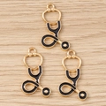 Detalle de colgantes de estetoscopio en metal dorado y esmalte negro para bisutería DIY - Estetoscopio Negro