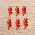 Detail of six red lightning bolt charms with gold plating on a wooden surface - 10 Pieces Pack / Red