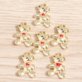 Detailed view of six golden alloy bear pendants with red bows on a wooden background - Gold