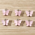 Detailed view of six pink butterfly charms with silver metal rings on a wooden surface - 10 Pieces Pack / Light Purple