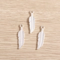 Verzilverde veerbladhangers voor DIY sieraden maken op een lichte houten ondergrond - Glanzend Zilver