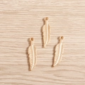 Macro detail van drie gouden veerhangers van legering op licht hout voor DIY-sieraden - Goud