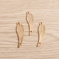 Detailopname van drie gouden engelenvleugel hangers met verfijnde verentextuur op hout - Set van 20 Stuks / Goud