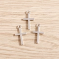 Detailansicht silberner Kreuzanhänger aus Legierung für DIY-Schmuck auf Holzhintergrund - Silber