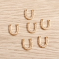Macro detail of golden horseshoe charms with GOOD LUCK engraving for DIY jewelry - 50 Pieces / Gold