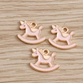 Tres colgantes de unicornio balancín en esmalte rosa con borde dorado sobre madera - Rosa
