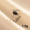Detalle de anillo ovalado de esmalte negro con borde de cuentas sobre tela de seda - Correa Plateada Esfera Negra