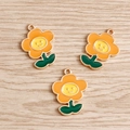 Dettaglio di tre ciondoli a forma di fiore in smalto colorato con volti sorridenti - Confezione da 3 / Arancione