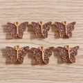 Detailed macro view of 6 gold alloy butterfly pendants with sparkling glitter resin inlay - 10 Pieces Pack / Coffee