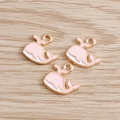 Detailed view of pink and white enamel whale pendants for DIY jewelry making - Pink