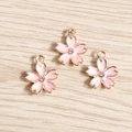 Macro shot of three pink enamel cherry blossom charms with center crystals on wood - 10 Pieces Pack / Pink