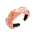 Gros plan du serre-tête en tissu rose avec des breloques en émail rouge et talons hauts - Rose