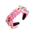 Detail eines rosa geknoteten Haarreifs mit bunten Herzperlen und funkelnden Strasssteinen - Rosa