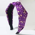 Close-up of knotted purple fabric headband featuring yellow star and moon celestial patterns - Purple