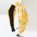 Macro detail of yellow knotted headband with bunny and easter egg print texture - Yellow