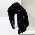 Close-up of black velvet knotted headband with red rhinestones and handmade label - Red