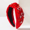 Dettaglio di fascia rossa annodata con toppe a cuore scintillanti e accenti di cristallo - Cuore Completo