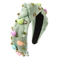 Détail d'un serre-tête en satin vert clair avec perles de cœur et cristaux étincelants - Vert