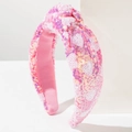 Close-up of pink sequined knot headband with white heart patterns and soft inner lining - Rose Pink
