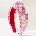 Detail of pink and gold sequin knotted headband featuring shimmering heart patterns - Red Pink