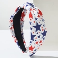 Détail du bandeau large noué avec des étoiles rouges et bleues sur un tissu blanc - Grande Étoile