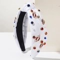 Detail of white knotted headband with blue and red rhinestones, pearls and football charms - White