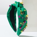 Detail of green knot headband with Mardi Gras beads, crown and mask metal charms - Green