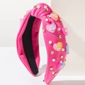 Detail van roze geknoopte hoofdband met harshart, parels en kristallen decoratie - rozenroze