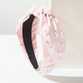 Détail du serre-tête en tissu rose avec perles synthétiques et breloques en cœur - Rose