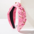 Détail du serre-tête rose noué orné d'appliques en forme de cœur et de strass brillants - Rose