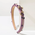 Detailed macro of vintage purple headband with gold bee accents and sparkling gemstones - Purple