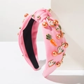 Diadema rosa anudada con perlas y dijes de conejo y zanahoria sobre base blanca - Rosa