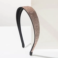 Close-up of sparkling champagne rose gold rhinestones on a slim black headband - Champagne