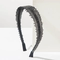 Diadema negra elegante con pedrería brillante sobre bloque geométrico blanco puro - Gris