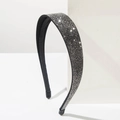 Detail of a sparkling black headband featuring closely set rhinestones on a white cube - Black
