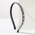 Detalle de una diadema negra fina decorada con pedrería redonda y en forma de diamante - Blanco