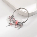 Detail eines silbernen Armreifs mit rosa Sternanhängern und Ballett-Anhänger - Rosa