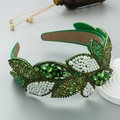 Detalle de diadema de terciopelo verde esmeralda con cristales y perlas de lujo - Verde