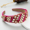 Detailed macro of fuchsia padded headband with colorful rhinestones on a display plate - Rose Red