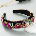 Dettaglio di cerchietto barocco di lusso con strass colorati e perla centrale raffinata - Rosa Rosso