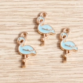 Detail of three light blue enamel flamingo charms with gold alloy plating for DIY jewelry - 10 Pieces Pack / Blue