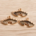 Three gradient bat wing charms with golden edges on wood background for DIY jewelry - Black