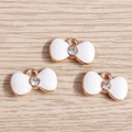 Detalle de colgantes de lazo en esmalte blanco con bordes de oro rosa y cristales finos - Blanco