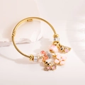 Bracciale a cavo intrecciato dorato con ciondoli a fiori rosa e farfalla - Rosa