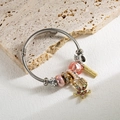 Verstellbares Charm-Armband mit rosa Kristallen und Seestern-Anhänger auf Steinuntergrund - Rosa