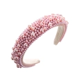 Detalle de diadema acolchada rosa con perlas artificiales sobre textura de tela suave - Rosa