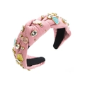 Détail d'un serre-tête rose noué orné de strass et de breloques en forme de cœur sucrés - Rose